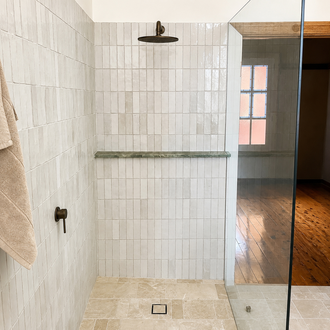 Interior of custom tiled walk-in shower with rainfall showerhead, stone shelf and natural stone flooring in an East Albury bathroom renovation.