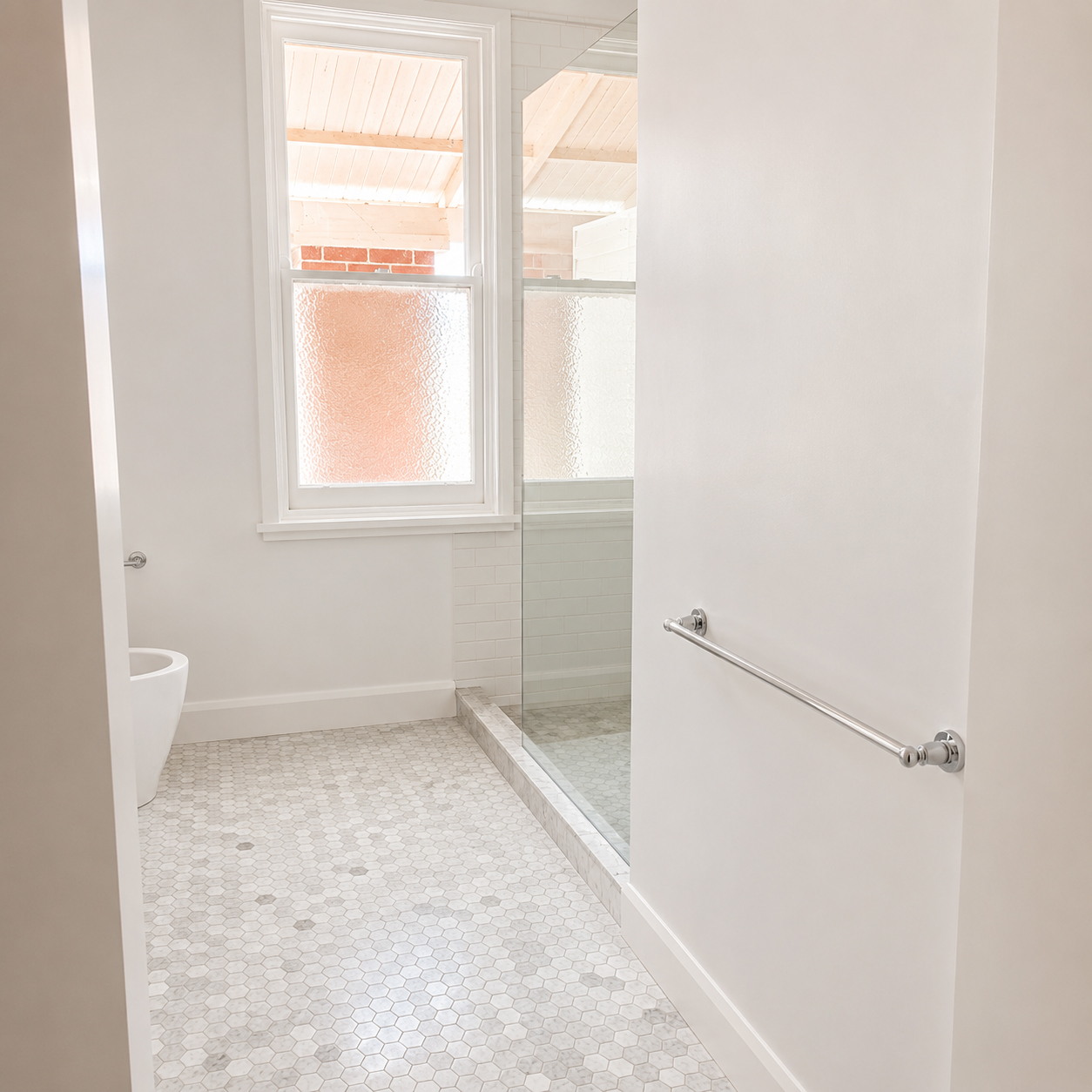 Heritage bathroom entry featuring marble mosaic flooring and custom joinery