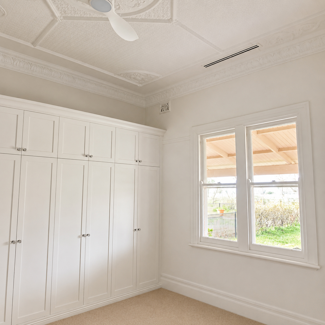 Heritage bedroom with custom built-in wardrobes and original ceiling details